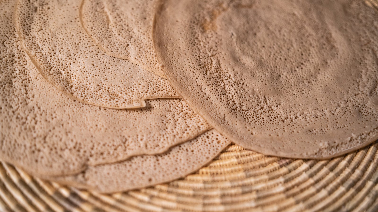 Rounds of fresh injera made from ivory teff in a woven basket